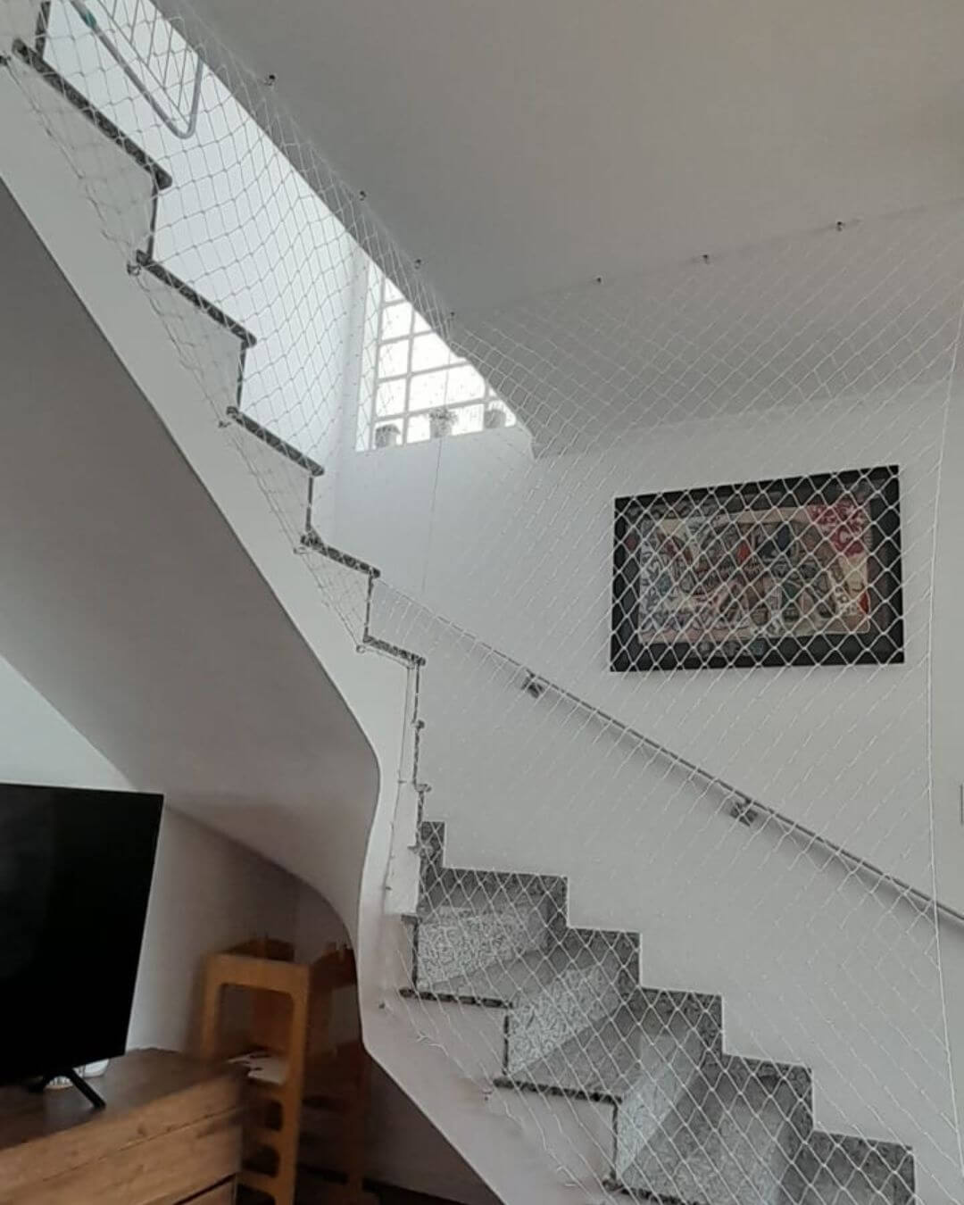 escada grande curvada com redes de proteção em toda sua lateral para proteção