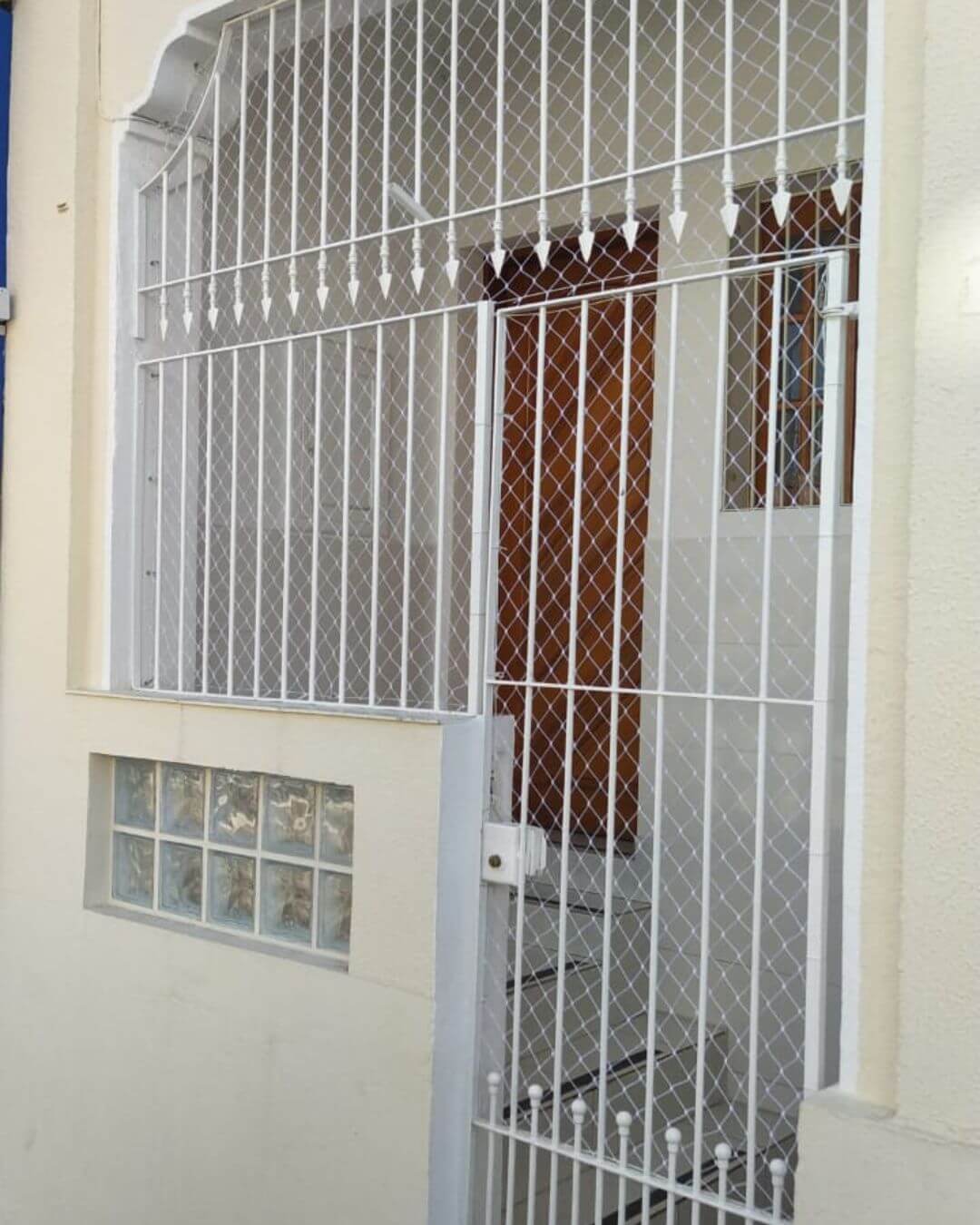 portão de uma residência com uma rede de proteção instalada