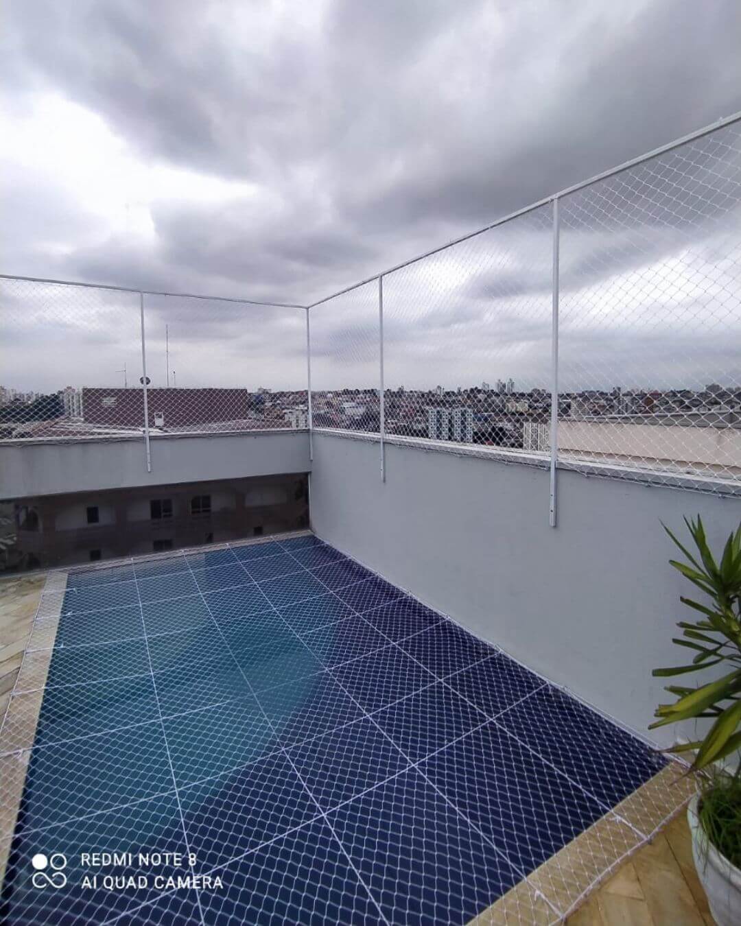 piscina de um condomínio coberta com rede de proteção